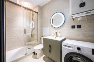 a bathroom with a washing machine and a toilet at Le Belmondo Grand Studio in Moutiers