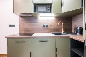 a kitchen with a sink and a microwave at Le Belmondo Grand Studio in Moutiers +14 photos