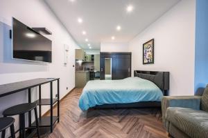 a bedroom with a bed and a living room at Le Belmondo Grand Studio in Moutiers