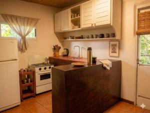 a kitchen with a counter top and a refrigerator at Refugio El Dormilón, Jardín cercado, Wifi, Playa 300 m, Pet friendly in La Pedrera