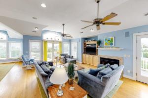 a living room with couches and a fireplace at The Nauti Flyer in Corolla