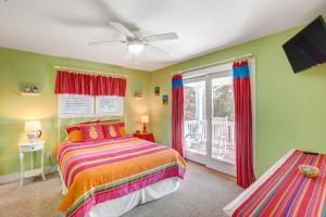 a bedroom with a colorful bed and a balcony at The Nauti Flyer in Corolla +44 photos