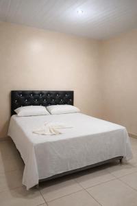 a bedroom with a large white bed with a black headboard at Hotel Star Rio in Novo Airão