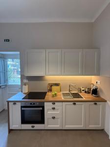 a kitchen with white cabinets and a sink at The Garden House in Tinos +21 photos