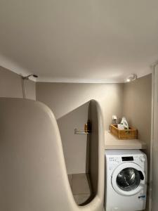 a bathroom with a washing machine in a room at The Garden House in Tinos
