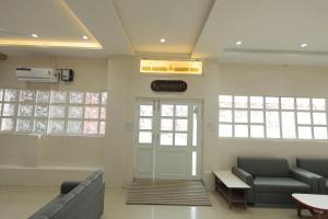 a waiting room with two couches and a door at Hotel Keshav Pride in Dhule
