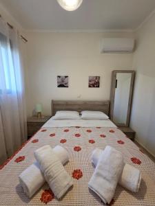 a bedroom with a bed with two towels on it at Christos Sunhaven Apartment in Agia Ermioni