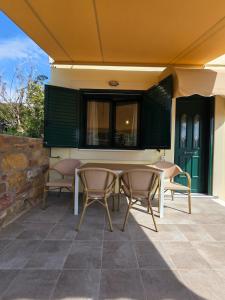 a patio with a table and chairs and a building at Christos Sunhaven Apartment in Agia Ermioni