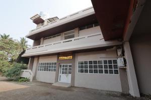 a building with a garage with a sign on it at Hotel Keshav Pride in Dhule