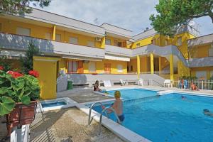a woman is standing next to a swimming pool at Piazzetta 293 in Rosolina Mare