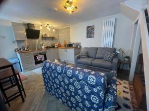 a living room with a couch and a kitchen at 3 Stable Mews in Holsworthy