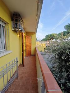 a balcony of a yellow building with a window at Piazzetta 293 in Rosolina Mare