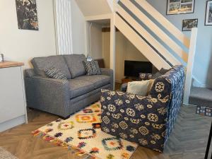 a living room with a couch and a chair at 3 Stable Mews in Holsworthy