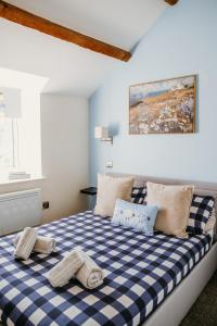 a bedroom with a blue and white checkered bed at Pauls Place in Brynsiencyn