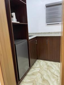 a small kitchen with a refrigerator and a counter at House 2 Guest House - Felele in Ibadan