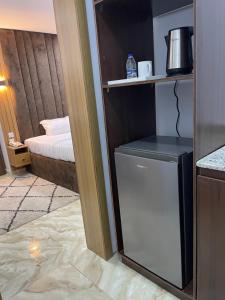 a small refrigerator in a room with a bed at House 2 Guest House - Felele in Ibadan