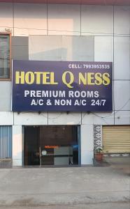 a hotel ess sign on the side of a building at Hotel Qness in Hyderabad +3 photos