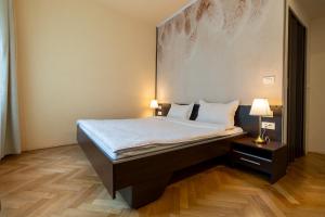 a large bed in a room with two lamps at Schiller Apartment - Old Town in Sibiu