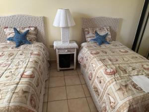 a bedroom with two beds and a table with a lamp at Mediterranean Caribbean View Village in Buena Vista