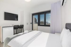 a white bedroom with a large bed and a window at Apartments Rea in Krk