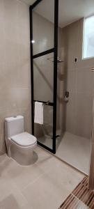 a bathroom with a toilet and a glass shower at Altitud 620 Boutique Suites in Nazca