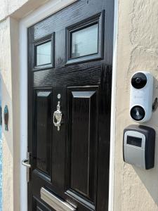 a black door with a mailbox on a house at Pauls Place in Brynsiencyn