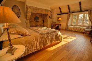 ein Schlafzimmer mit Bett und Steinkamin in der Unterkunft KERBELEG, ferme-manoir du XVè siècle, chambres grand confort in Riec-sur-Bélon