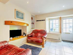 a living room with a red chair and a television at 2 Bed in Aberdyfi oc-dy015 in Aberdyfi