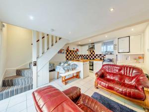 a living room with two leather couches and a kitchen at 2 Bed in Aberdyfi oc-dy015 in Aberdyfi