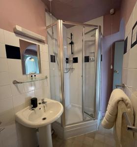 a bathroom with a shower and a sink at Smugglers Hotel in Brixham