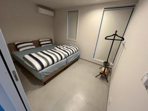 a bedroom with a bed and a lamp in it at Laina Kai in Sumoto
