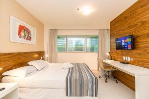 a hotel room with a bed and a desk with a computer at Vision Diária Brasil 08200 in Brasília
