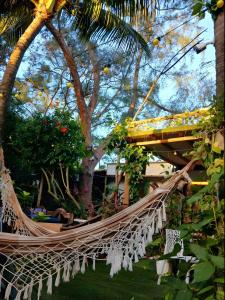 a hammock in a garden with palm trees at Casa de Mirtes in Fernando de Noronha