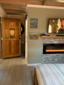 ein Schlafzimmer mit einem Kamin und einem Fernseher darüber in der Unterkunft Mayne Cottage in Mayne Island