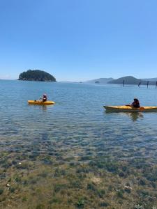 zwei Personen in Kajaks auf einem großen Gewässer in der Unterkunft Mayne Cottage in Mayne Island + 4 Fotos