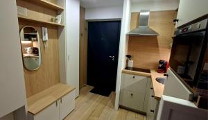 a small kitchen with a black door and a sink at Le "BonLieu" - Annecy Lac & Centre Ville in Annecy +22 photos