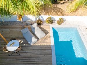 a swimming pool with two chaise lounges and a table and a pool at Villa CuraSol in Jan Thiel