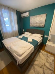 a bedroom with a large bed with white sheets at Zlatibor Royal Centar Lux in Zlatibor