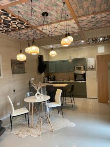 a kitchen with a table and chairs and lights at La maison du bois brulée 5 in Villaines-les-Rochers