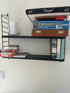 a shelf with books and a bowl on a wall at Tunneberga 1 65 in Jonstorp