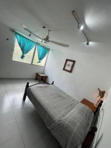 ein Schlafzimmer mit einem Bett und einem Fenster mit blauen Vorhängen in der Unterkunft Mi Refugio Dive House in Cozumel