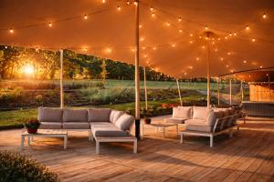 a patio with couches and lights under a tent at Le Domaine de Bra in Bra