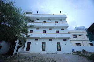 a white building with windows on the side of it at LK.Lodge in Kanyakumari