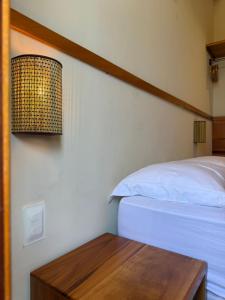 a bedroom with a bed and a wooden table at Casa Floratta - Flecheiras in Flecheiras