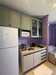a kitchen with a white refrigerator and a sink at Casa Floratta - Flecheiras in Flecheiras