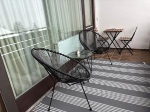 two chairs and a glass table on a balcony at AuszeitOase inkl Oberstaufen Plus Karte in Oberstaufen