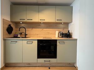 a kitchen with white cabinets and a black microwave at AuszeitOase inkl Oberstaufen Plus Karte in Oberstaufen