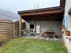 a patio with a grill and a table and a picnic table at Appartement 4 personnes - Laruns in Laruns