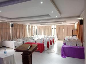 a banquet hall with white chairs and tables and a podium at Fidel Hotel in Bahir Dar