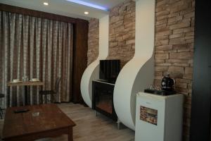 a living room with a tv and a brick wall at Hera Suit Ataşehir in Istanbul